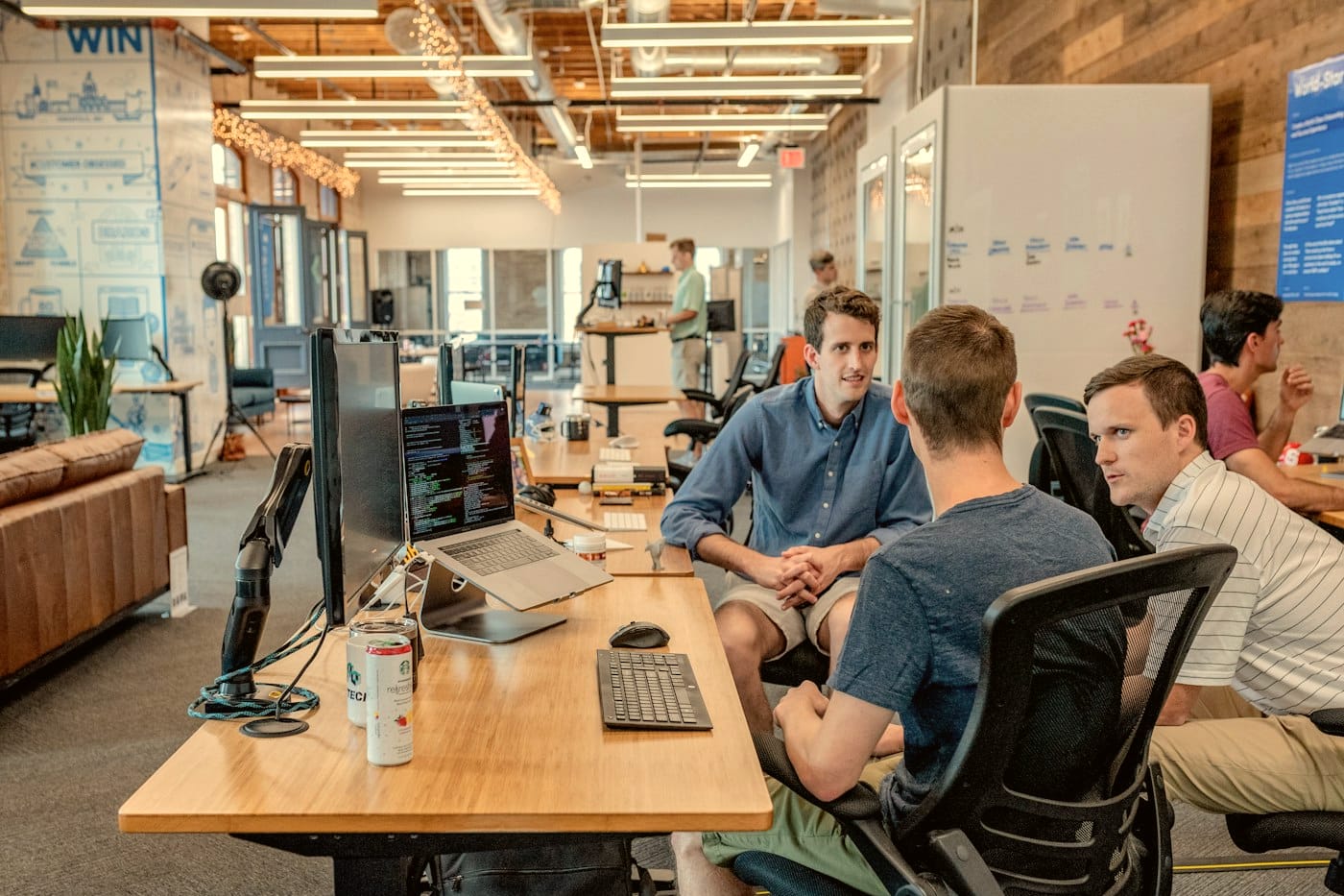 A small investment team working together around a table in an open office