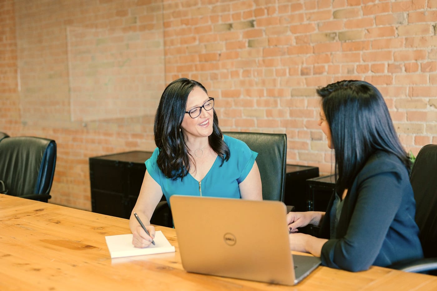Two people across a table going through an investor presentation on paper