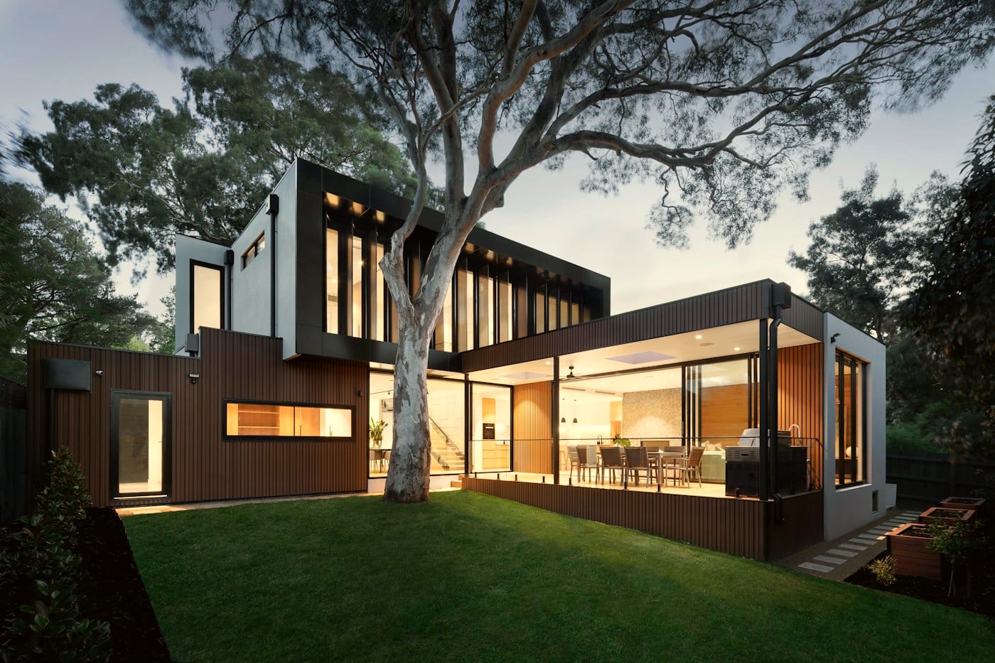 A newly built house with lights on at dusk